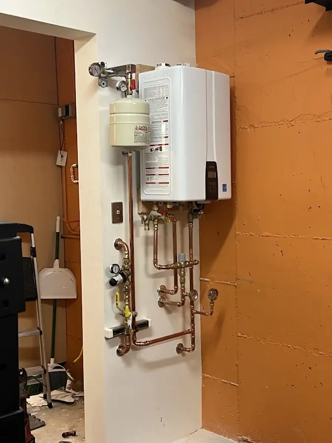 Plumbing technician inspecting water heater connections in McAlester